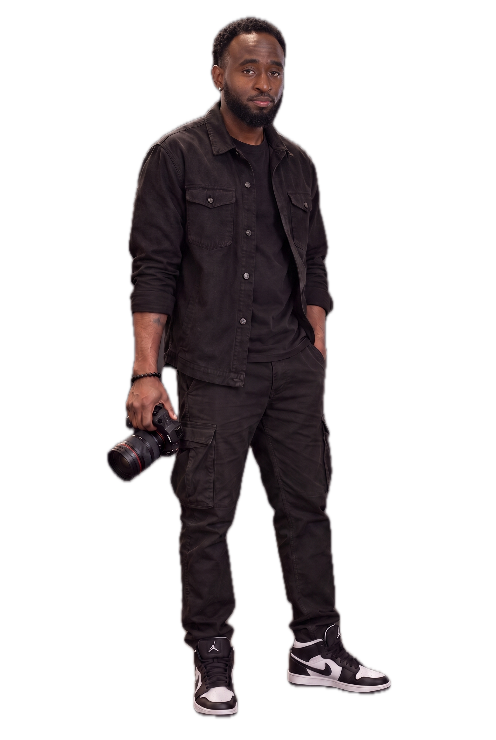 Marquise Johnson holding his camera, wearing a black overshirt, T-shirt, cargo pants and black-and-white sneakers.